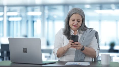 Angry-Indian-senior-female-manager-chatting-on-phone