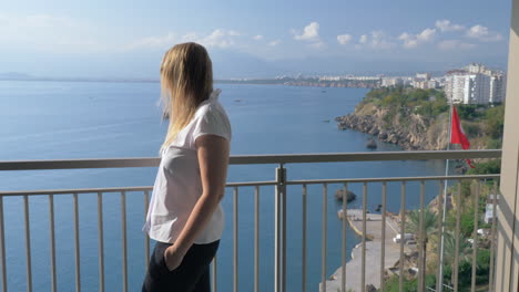 a woman talking to the phone on a hotel balcony against the beautiful scenery