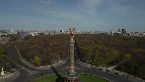 AERIAL:-Close-Up-Dolly-of-Berlin-Victory-Column-Golden-Statue-Victoria-in-Beautiful-Sunlight-and-Berlin,-Germany-Cityscape-Skyline-in-Background