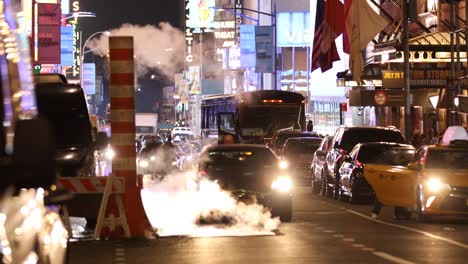 manhattan, new york - september 18, 2019:  people and cars cross the road  by the digital advertising and brightly lit billboards of broadway in times square new york city usa