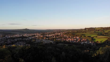 Luftaufnahme-Mit-Blick-über-Die-Stadt-Honiton-Mit-Den-Blackdown-Hills-Und-Der-Landschaft-Von-East-Devon-Im-Hintergrund