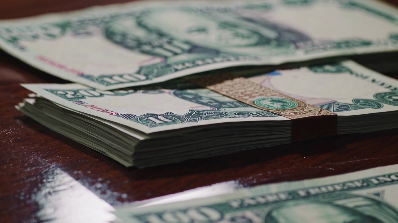 Stacks of Money Bills on a Wooden Table