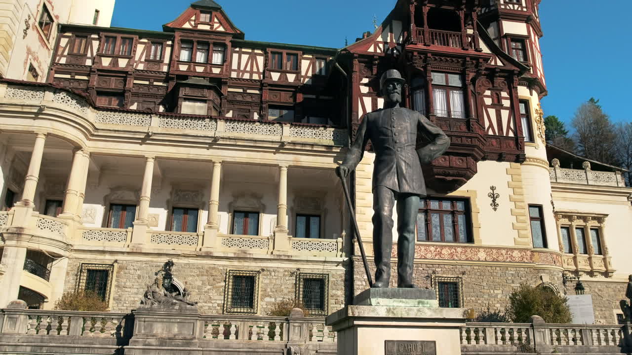 King Carol statue at The Peles Castle in Romania. Castle on the background