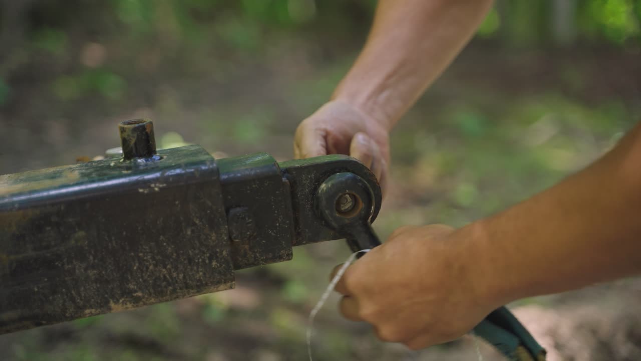 야외에서 고기 에 장비를 부착하는 노동자의 클로즈업.