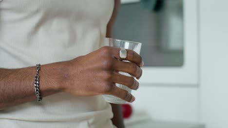 man drinking a beverage in a kitchen