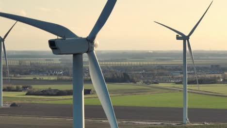 Nahaufnahme-Der-Rotierenden-Rotorblätter-Von-Windkraftanlagen-In-Einer-Ländlichen-Gegend-Bei-Sonnenuntergang