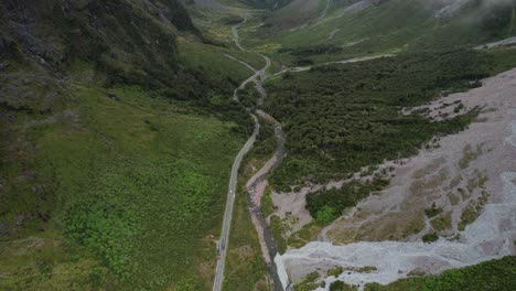 Milford-Road-to-Milford-Sound,-aerial-of-New-Zealand-scenic-drive,-high-mountains-landscape