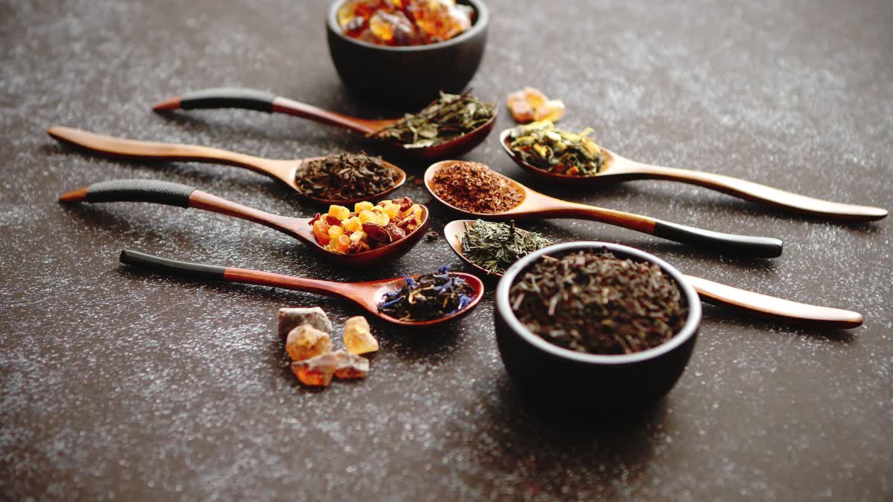 다양한 종류의 마른 찻잎이 있는 숟가락