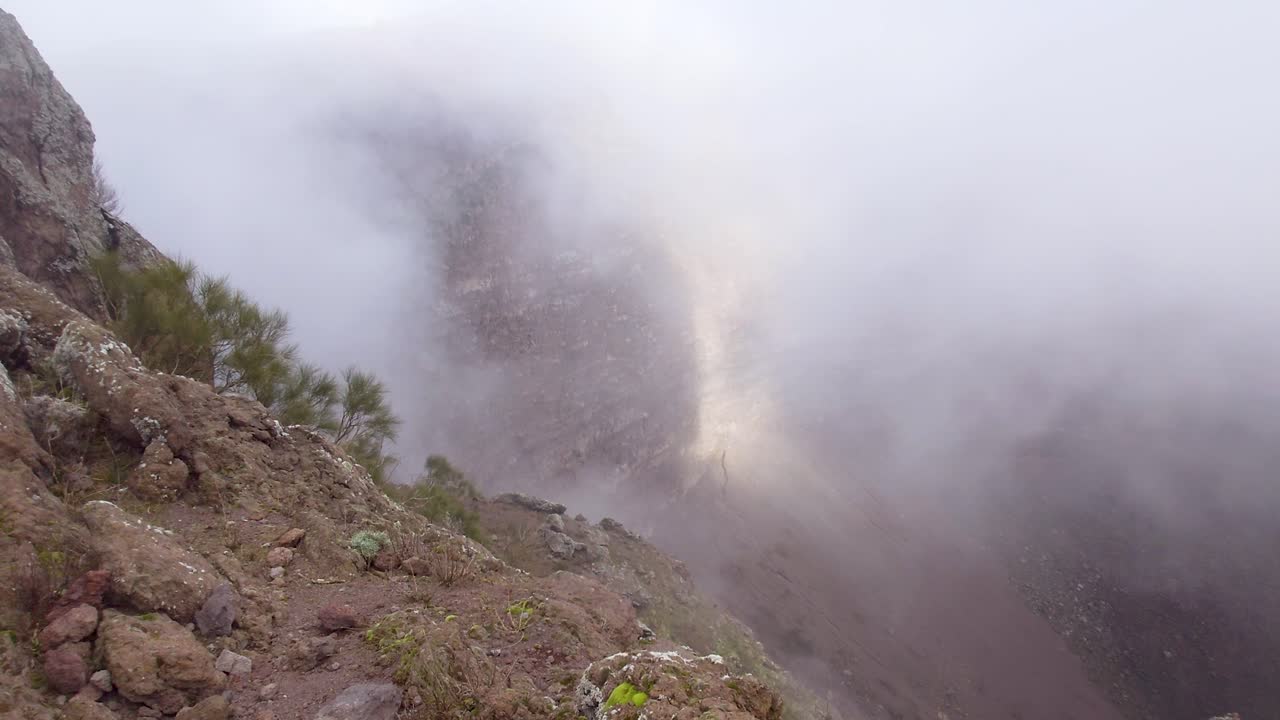 una vista de nubes de niebla que se derraman en el cráter del monte vesubio - nápoles, italia