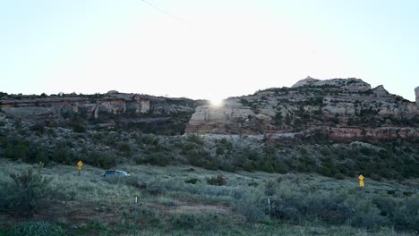 Sun-setting-behind-red-rock-mountains-in-the-Colorado-National-Monument,-time-lapse