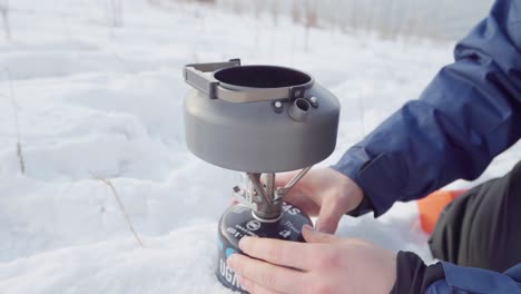 Camper,-Der-Im-Winter-Einen-Camping-Teekanne-Wasserkocher-Auf-Einem-Tragbaren-Herd-Zusammenbaut