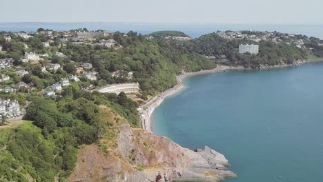 aerial fly over of beautiful coastline towards small town