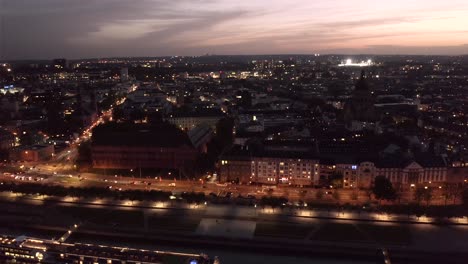 neustadt part of mainz in the evening after sunset with glow on the sky by a drone showing a rhine river ship on the dark water