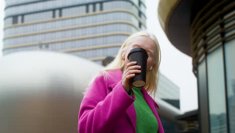 Happy-woman-holding-coffee-cup-outdoors