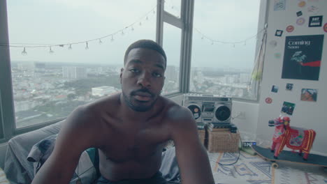 young african-american man posing on camera in his bedroom