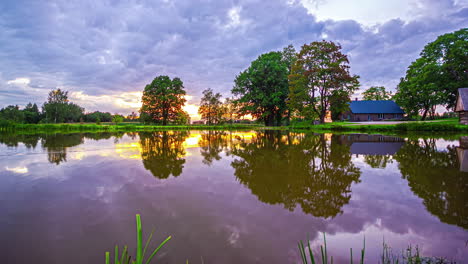 Hermoso-Timelapse-De-Un-Estanque-Tranquilo-Con-árboles-Y-Una-Casa-Reflejada-En-El-Agua,-El-Color-Cambia-Con-El-Movimiento-Del-Sol