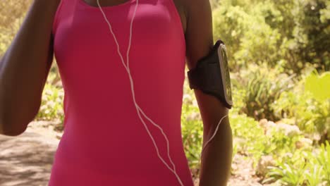 Close-up-of-sportswoman-is-listening-music-in-a-park-