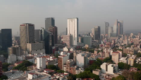 Vista-Aérea-Del-Centro.-Drone-Volando-Hacia-Altos-Edificios-De-Oficinas.-Visibilidad-Limitada-Debido-A-La-Contaminación-Del-Aire.-Ciudad-De-México,-México.