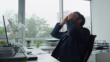 upset man calling mobile at office workplace. stressed manager thinking problems