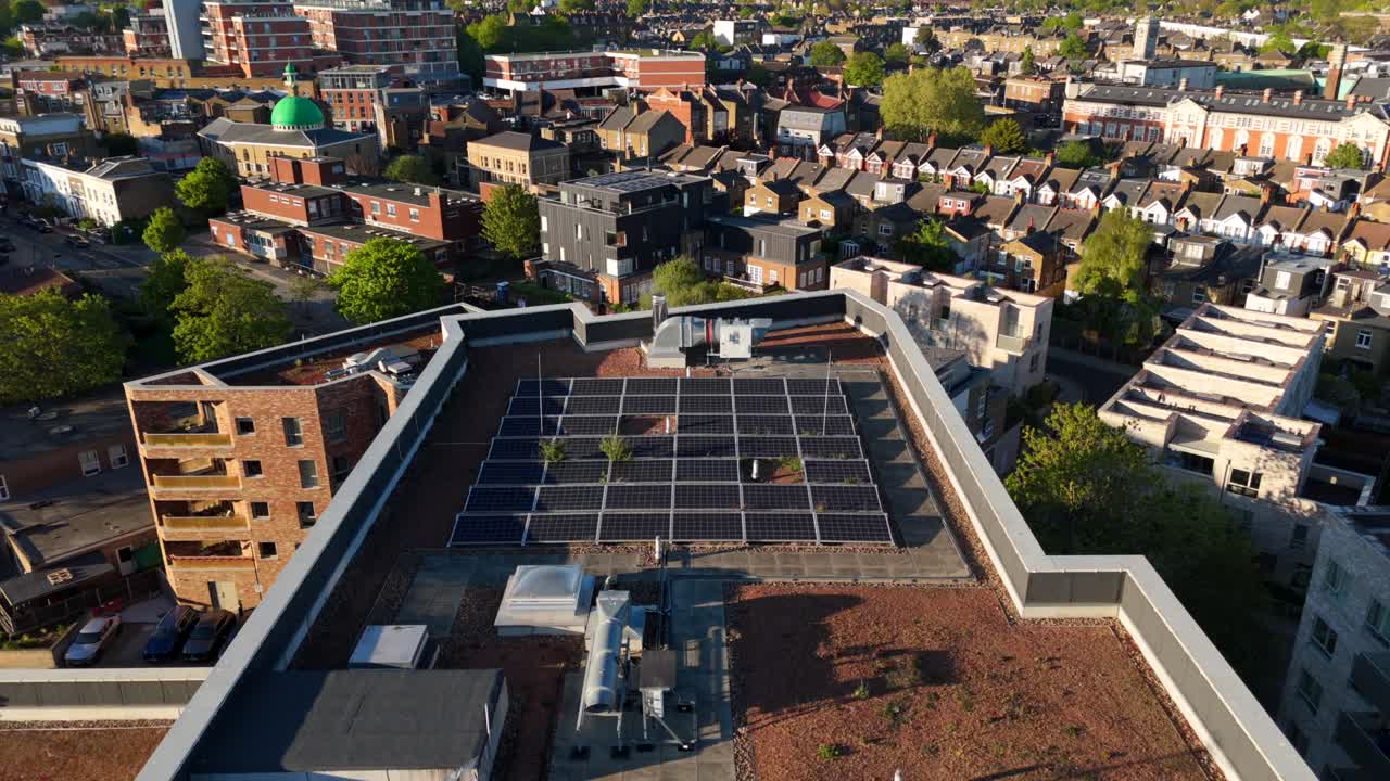 Aerial view flying over modern high rise rooftop solar panels with London skyline