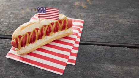 video of hot dog with mustard and ketchup with flag of usa on a wooden surface