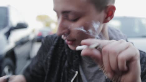 tourist woman smoking marijuana in the parking lot in canada - close up shot