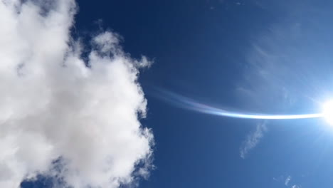 clouds and sun moving through the frame then tilting down to the mojave desert landscape in this dynamic time lapse