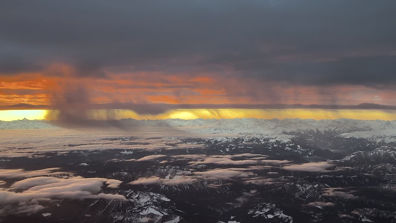 Luftfoto af en solopgang, taget fra et jetcockpit under flyvning over Alperne dækket af sne