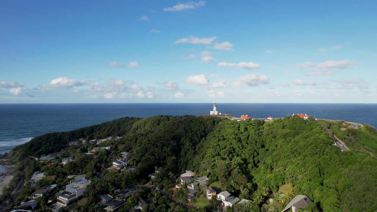 은 푸른 하늘 아래 어져있는 집과 등대와 함께 울창한 바이론 만 해안 풍경