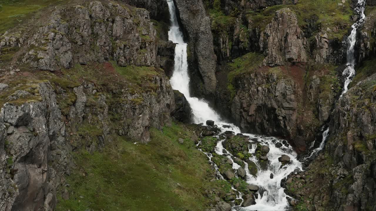 elevándose en una poderosa cascada con agua blanca cayendo desde un acantilado volcánico