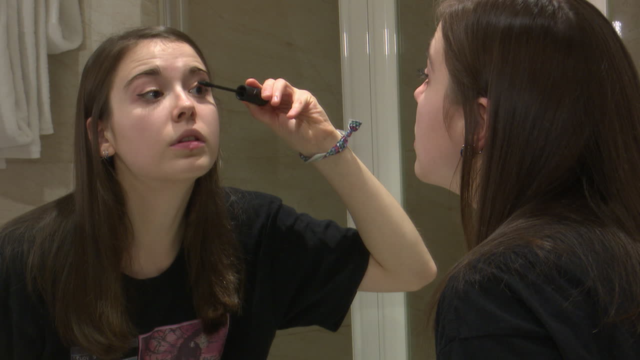 Teenage Girl Applying Mascara in Bathroom