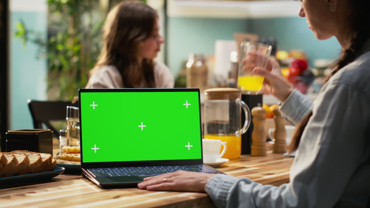 Mockup laptop display with family gathered for breakfast in the kitchen