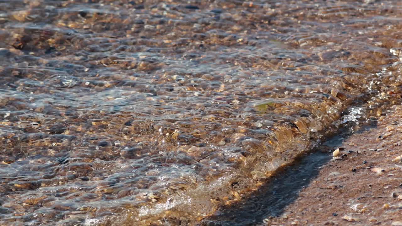 Onde che lambiscono dolcemente la spiaggia sabbiosa