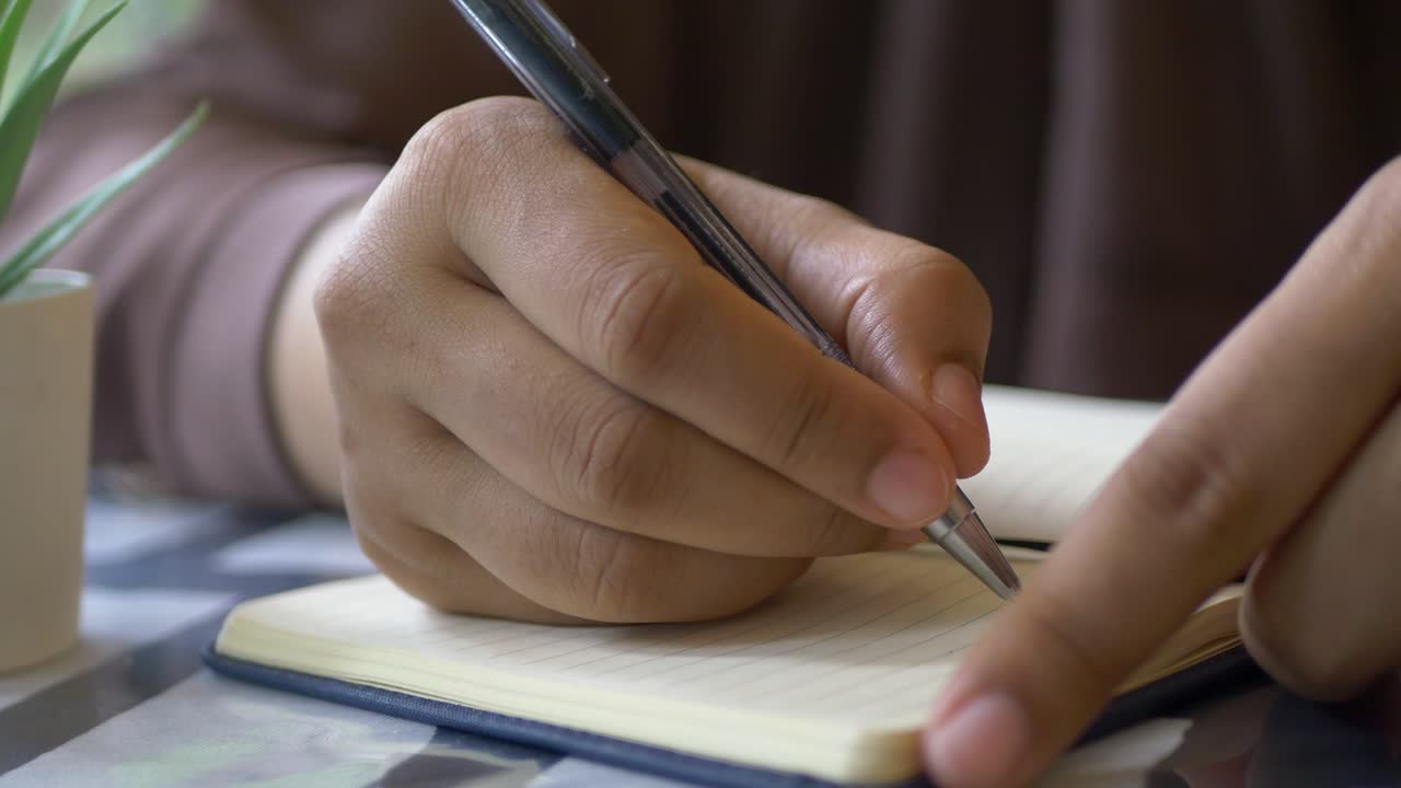 Close up of women hand writing on notepad
