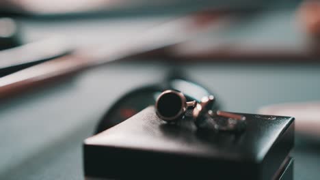 elegant-wedding-rings-in-focus-siting-on-a-gift-box,-while-all-objects-are-on-a-pool-table