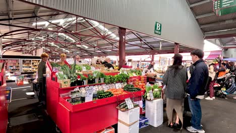 shoppers browse fruit and vegetables at market