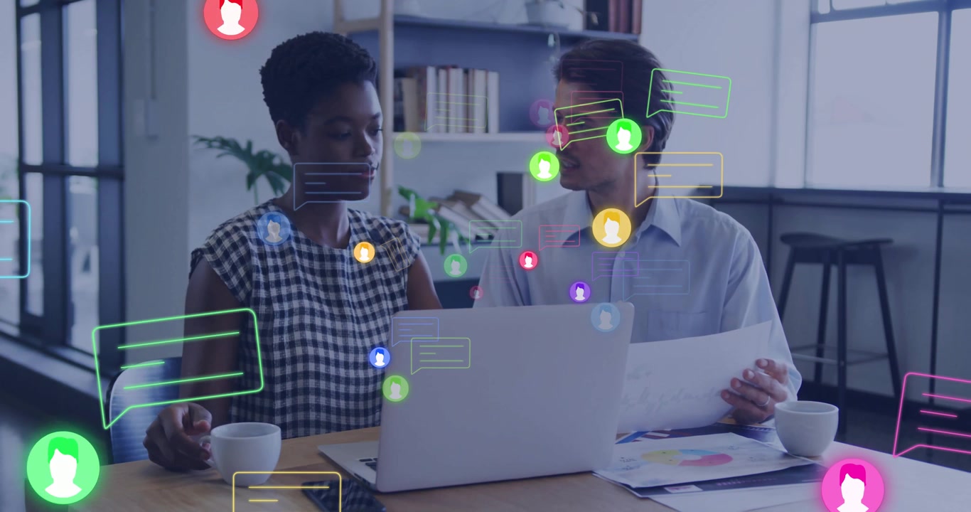 Coworkers reviewing business charts in modern office, showing floating chat bubbles and avatars