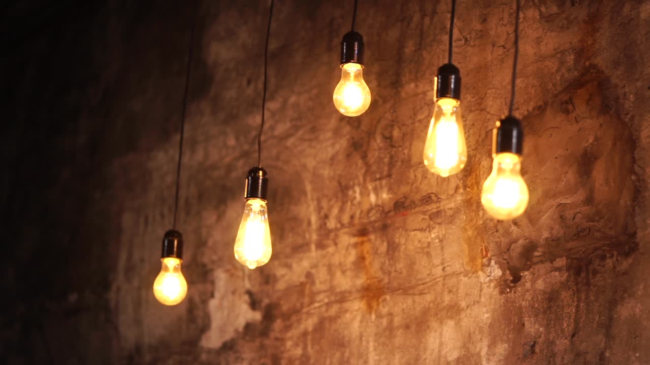 bombillas edison antiguas colgando en una pared de ladrillo