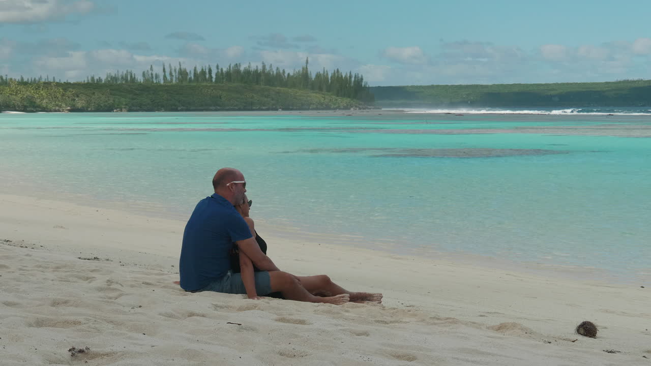 Adult caucasian couple enjoy ocean view on Maré, Loyalty Islands, New Caledonia