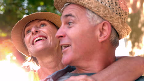 Senior-woman-giving-her-partner-a-kiss-on-sunny-day-