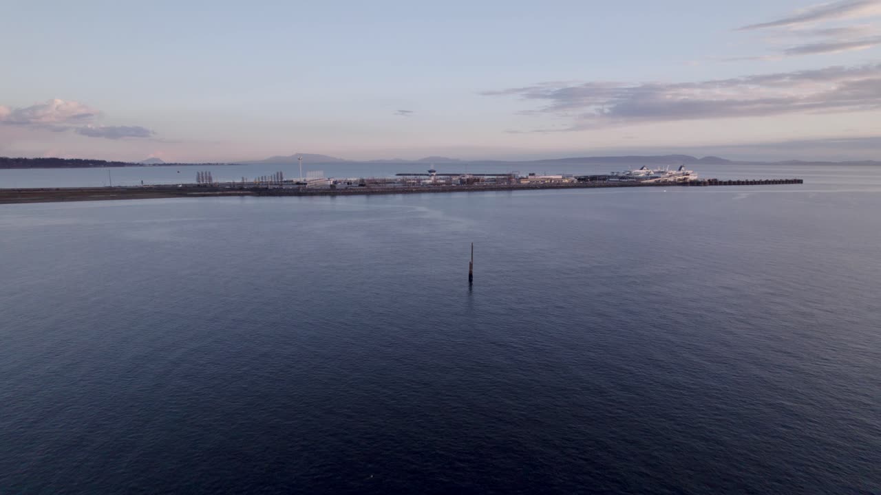 Tsawwassen BC färjeterminal i Vancouver, Kanada, flygvy över hamnen med båt redo att segla på havsvattnet under solnedgången.