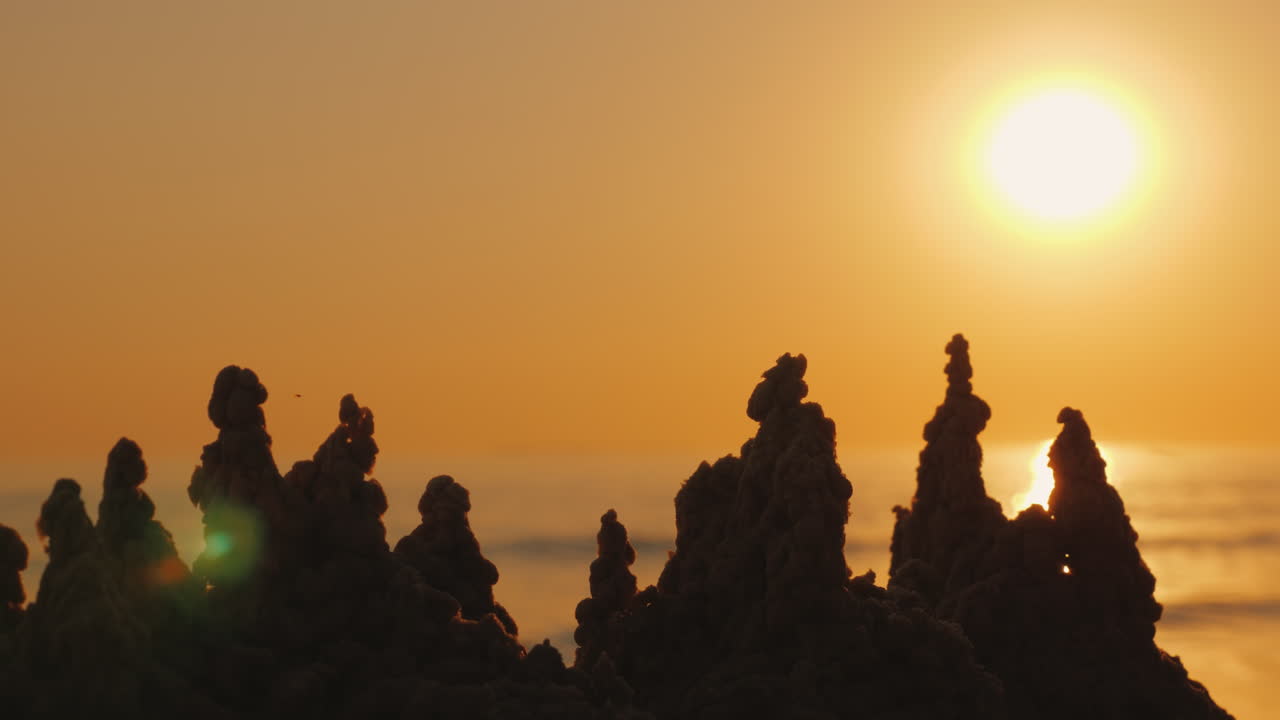 la mano del niño construye un castillo de arena en la playa 4k video