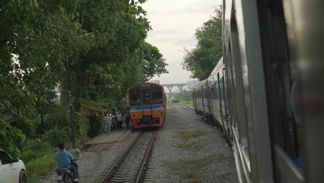 Train-Passing-Another-Train-Unloading-Passengers-In-Bangkok-Thailand