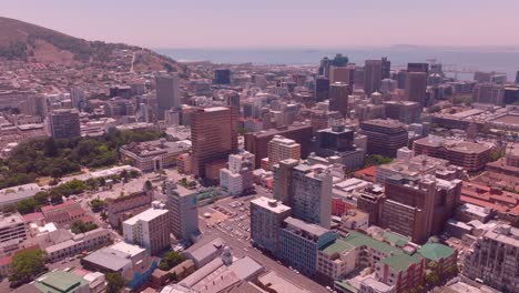 a drone shot slowly orbits around the central city building of cape town and the overall environment of the city