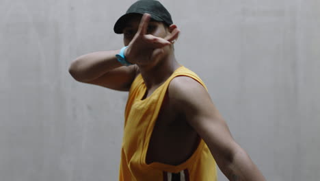 dancing man young happy street dancer performing various freestyle dance moves fit mixed race male practicing in grungy warehouse wearing yellow vest close up