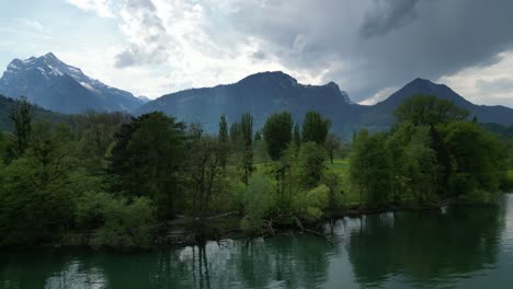 Dreamlike-Alpine-forests-and-mountains-adorning-lake-in-Switzerland