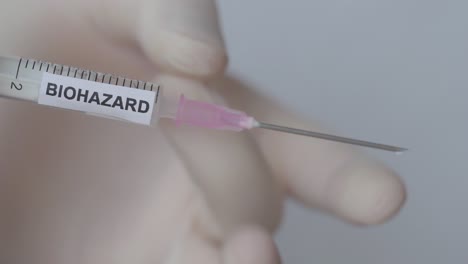 Hand-Wearing-Medical-Gloves-Flicking-Bubble-Out-Of-Syringe,-Close-Up-Shot