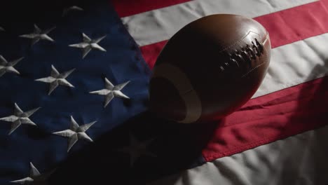 Low-Key-Lighting-Studioaufnahme-Des-American-Football-Mit-Helm-Auf-Der-Stars-and-Stripes-Flagge-1