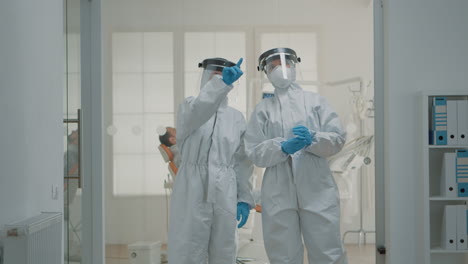 team of caucasian dentists with hazmat suits discussing prevention