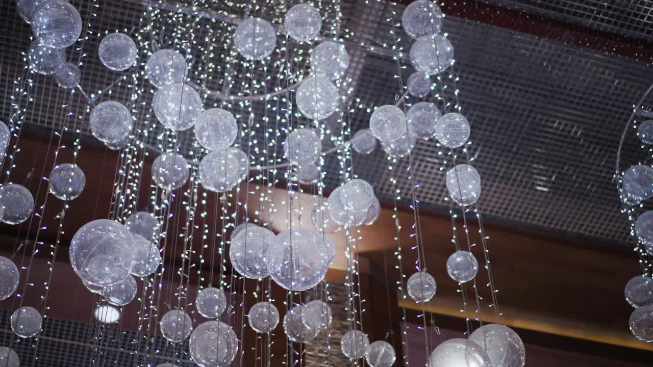 primer plano de la brillante decoración festiva con esferas translúcidas y luces parpadeantes, creando un ambiente mágico y elegante adecuado para las celebraciones navideñas